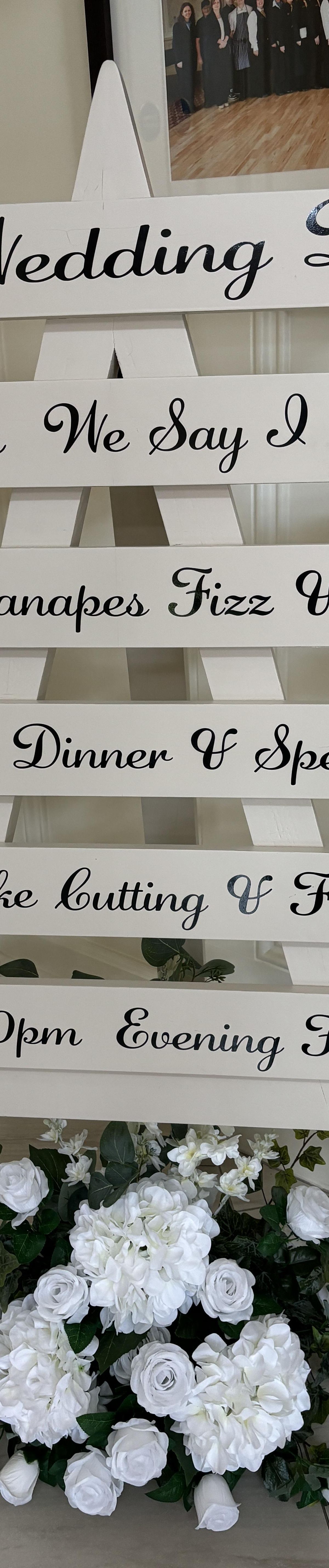 Order of service sign with florals