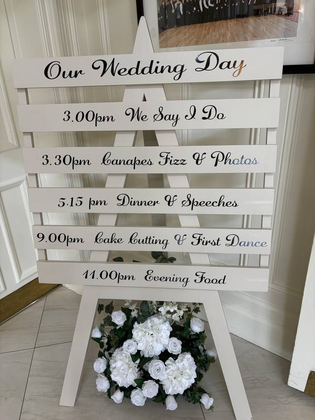 Order of service sign with florals